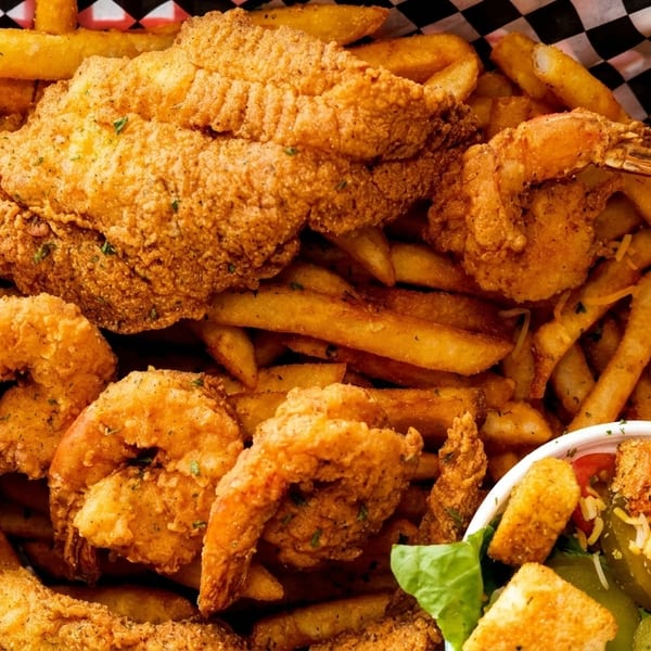 Crispy fried fish and shrimp with french fries, garlic toast, and a side salad.